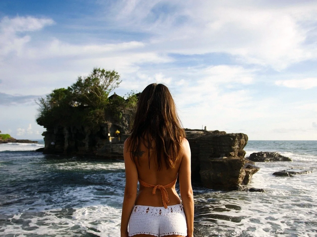 Девушка брюнетка красивая на берегу в шортах
