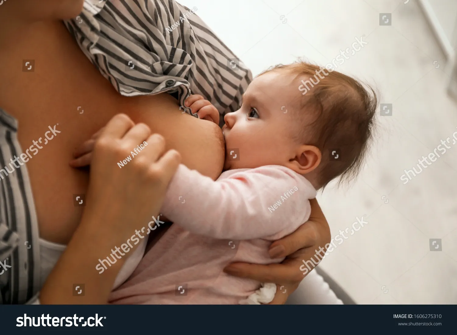 Голая женщина кормит ребенка