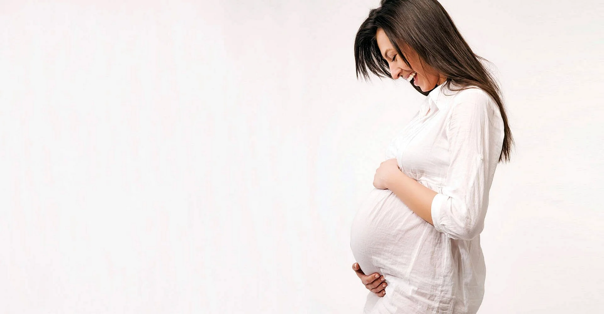 Беременная женщина на однотонном фоне