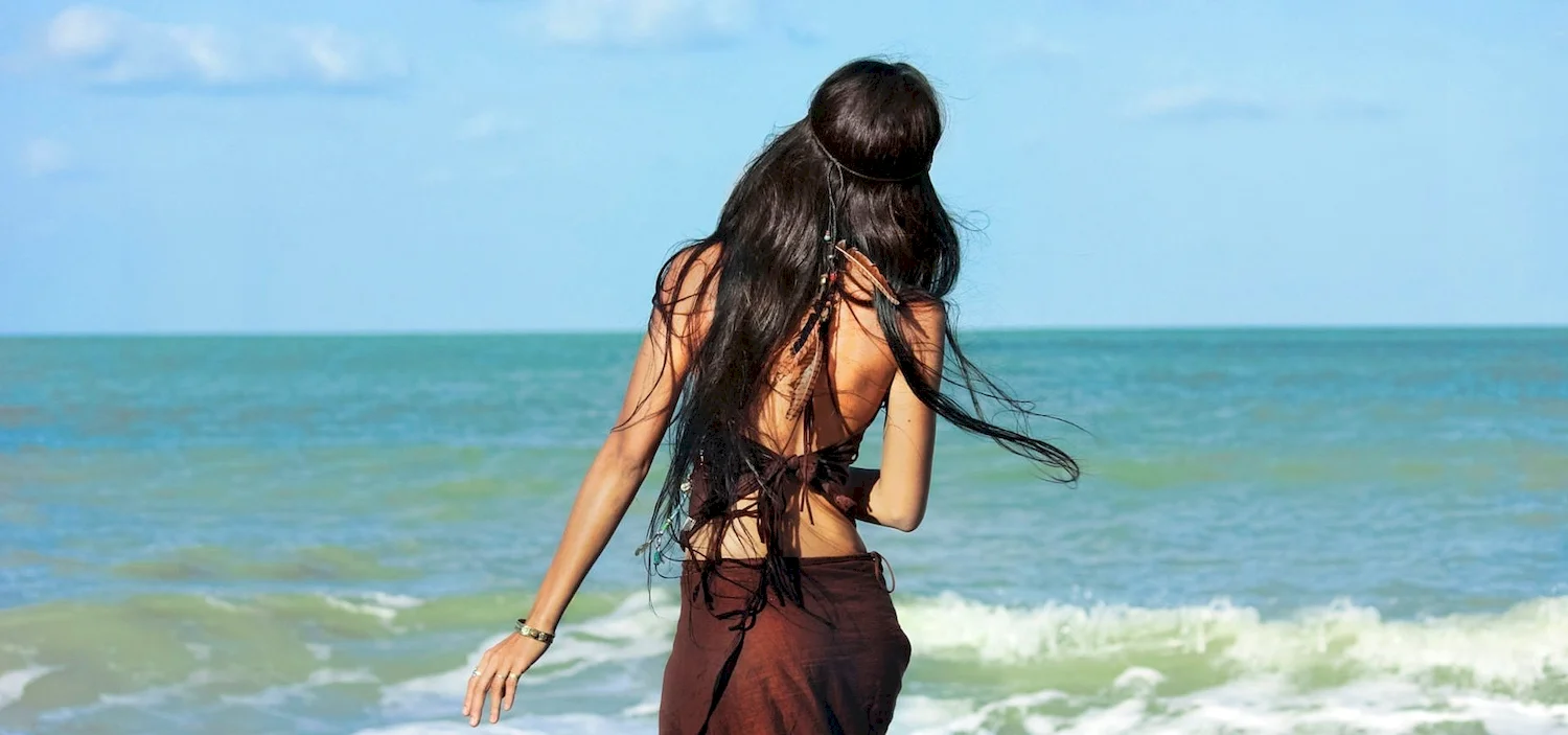 Брюнетка с длинными волосами на море