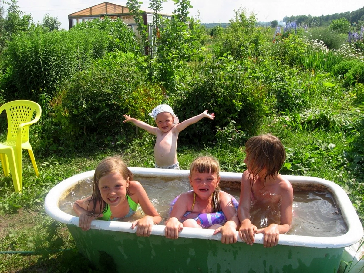 Дети в бассейне на даче купаются