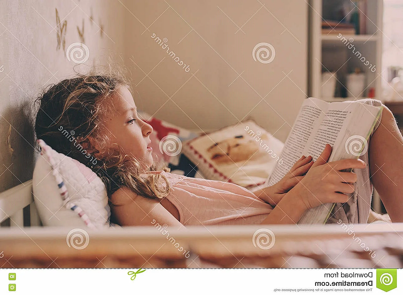 Девушка читает книжку на кровати