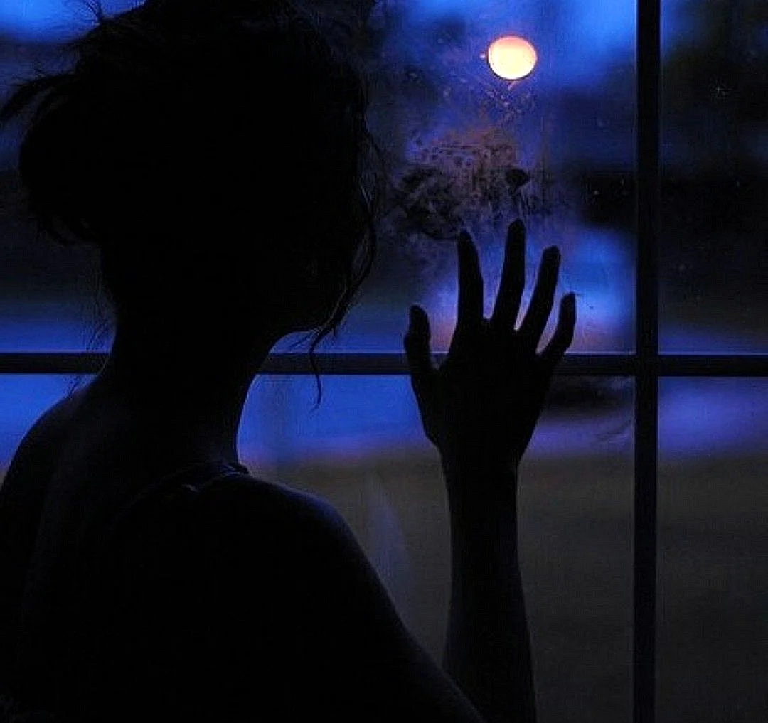 Девушка на окне в темноте