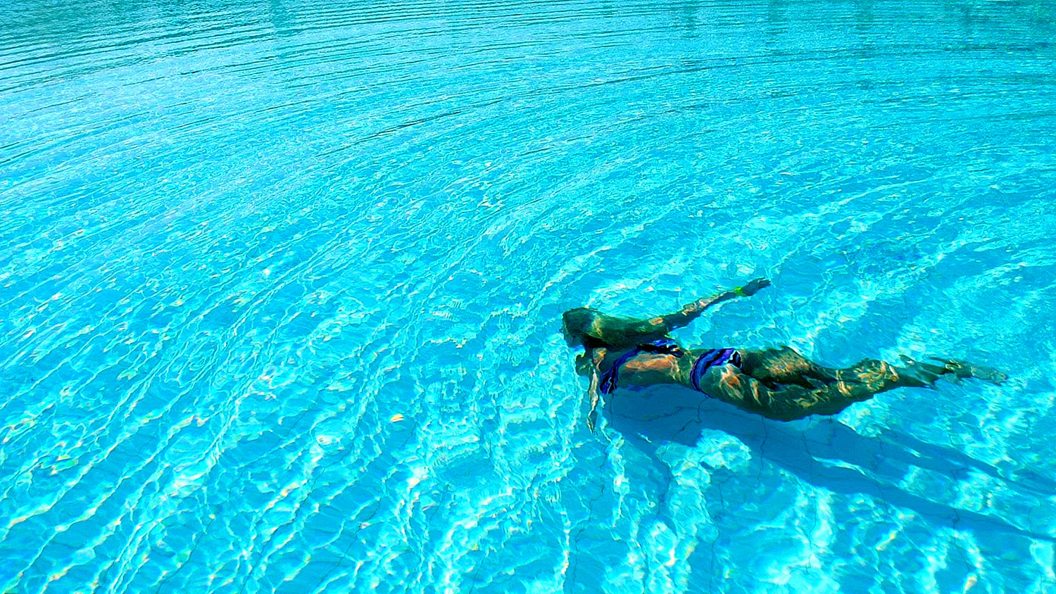 Девушка ныряет в бассейн