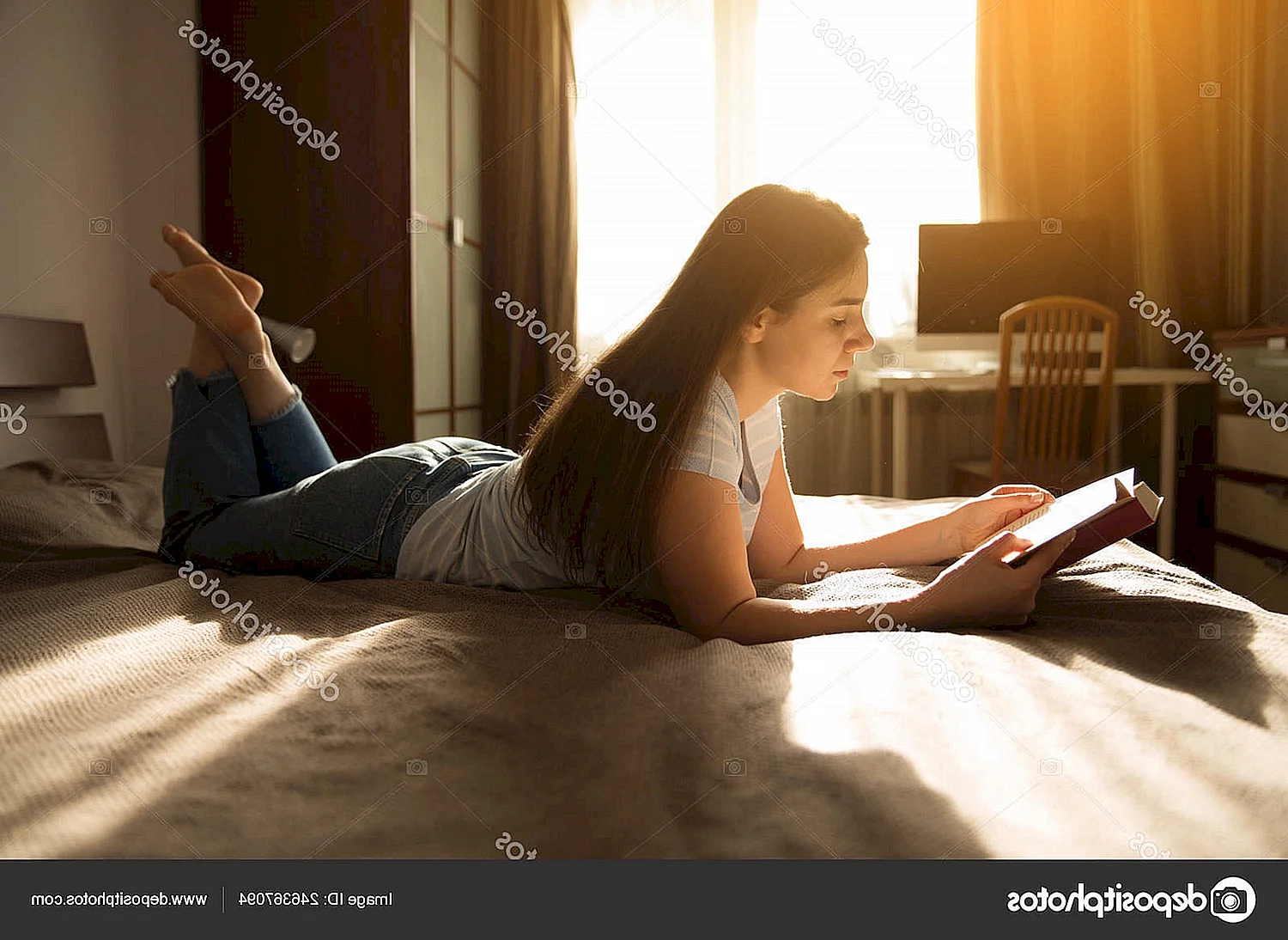 Девушка сидит на кровати с книгой