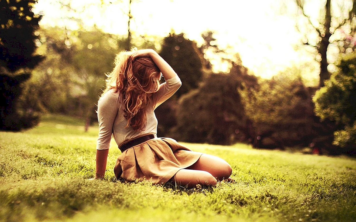 Девушка сидит на траве