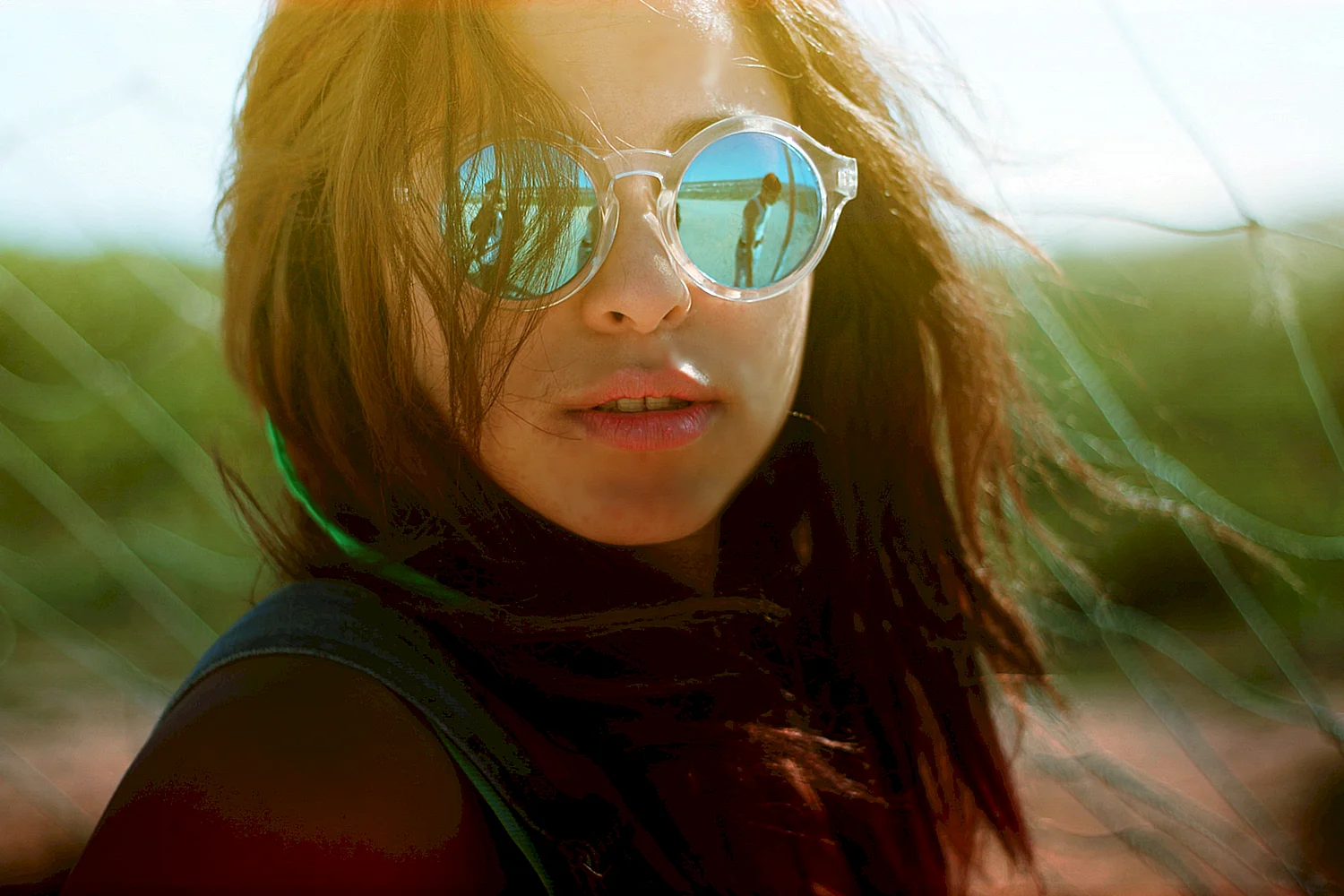 Девушка в солнечных очках на однотонном фоне