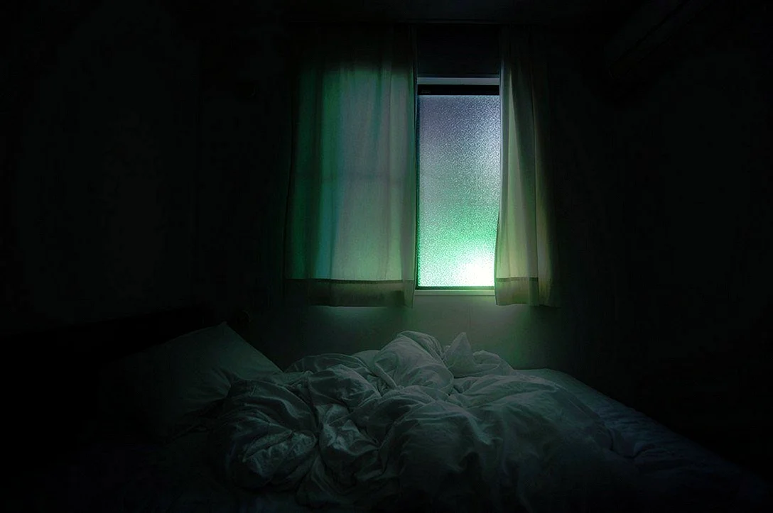 Комната с кроватью в темноте