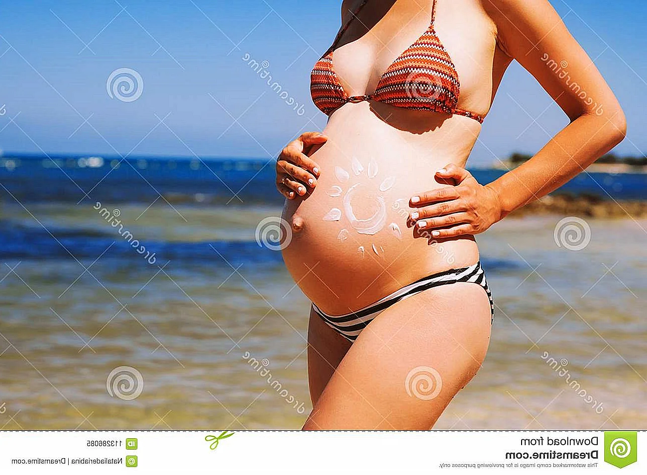 Красивый беременный животик на пляже