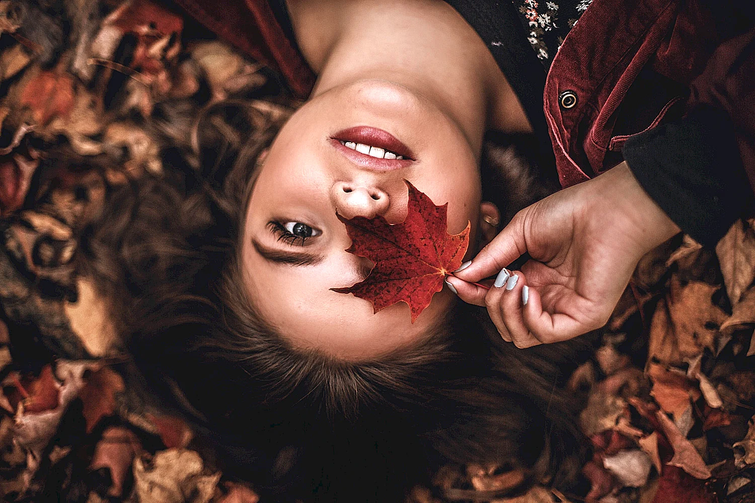 Лицо девушки в осенних листьях