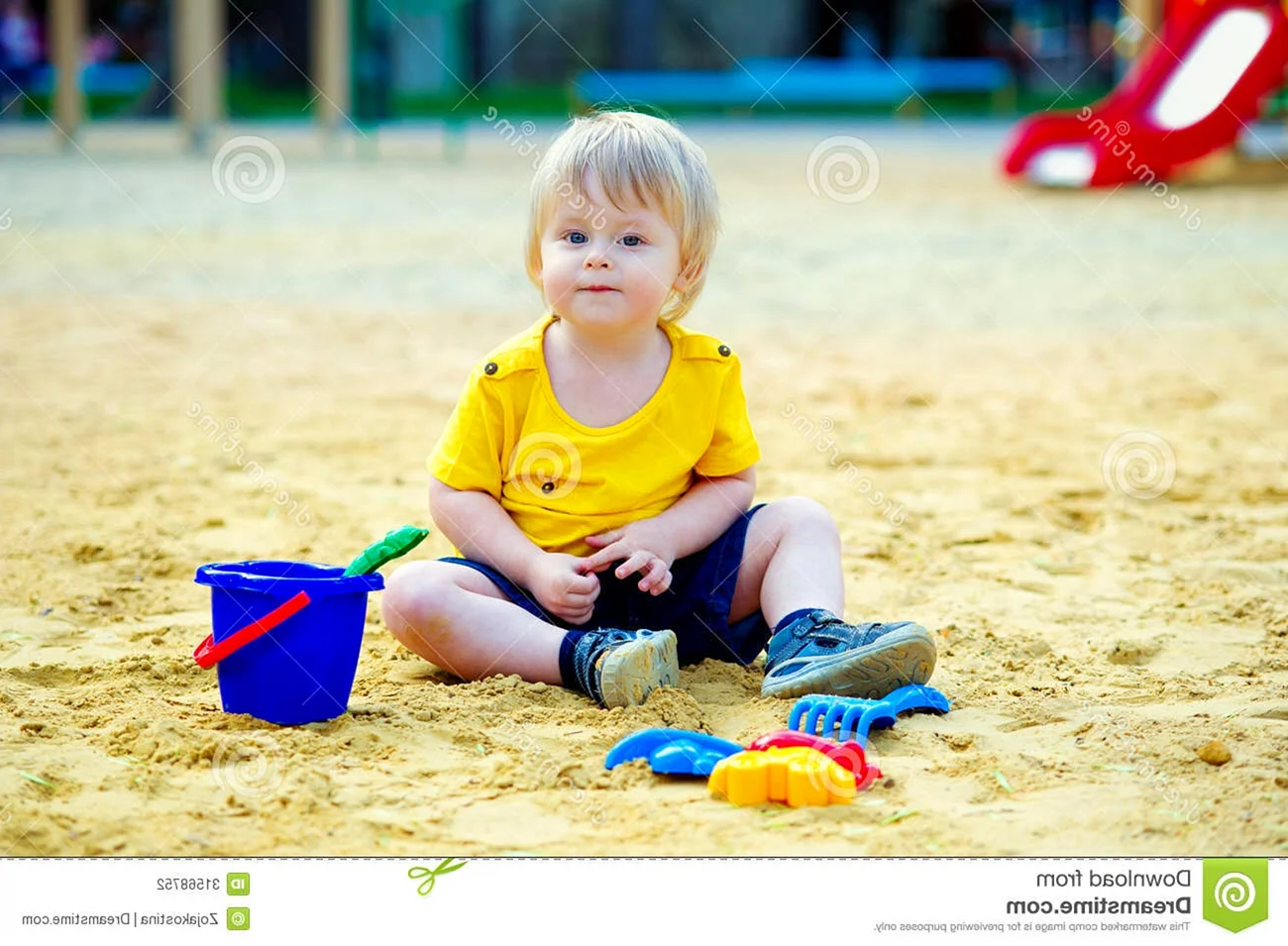 Мальчик сидит в песочнице