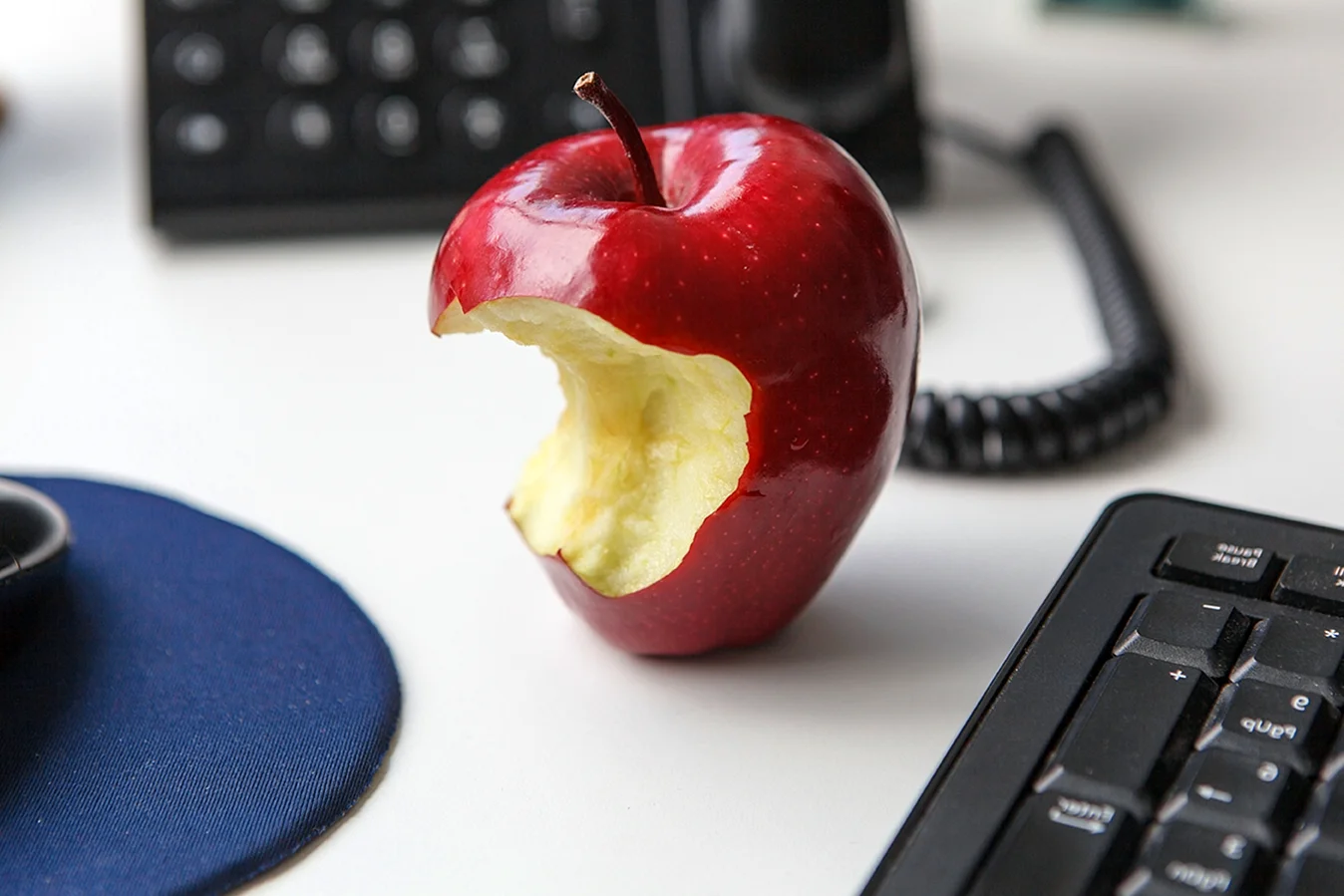 Надкушенное яблоко на столе