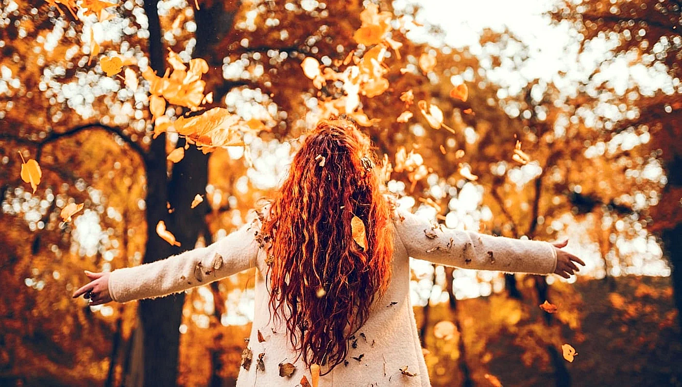 Девушка с рыжими волосами осенью