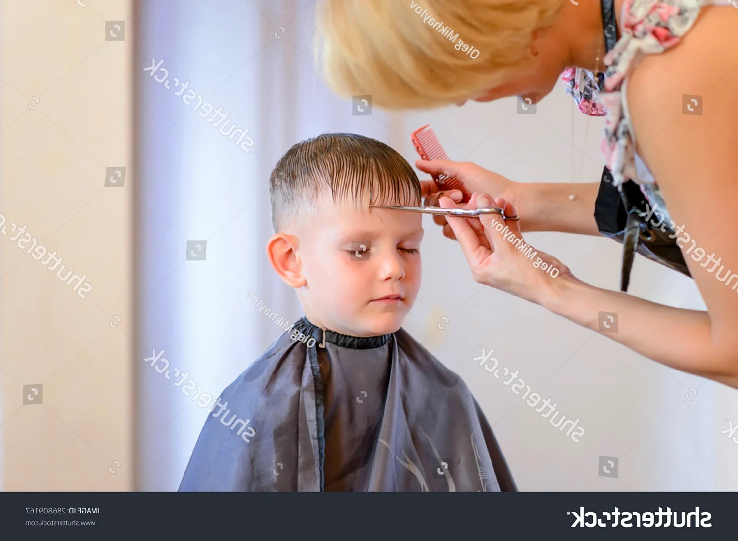 Парикмахер стрижет мальчика