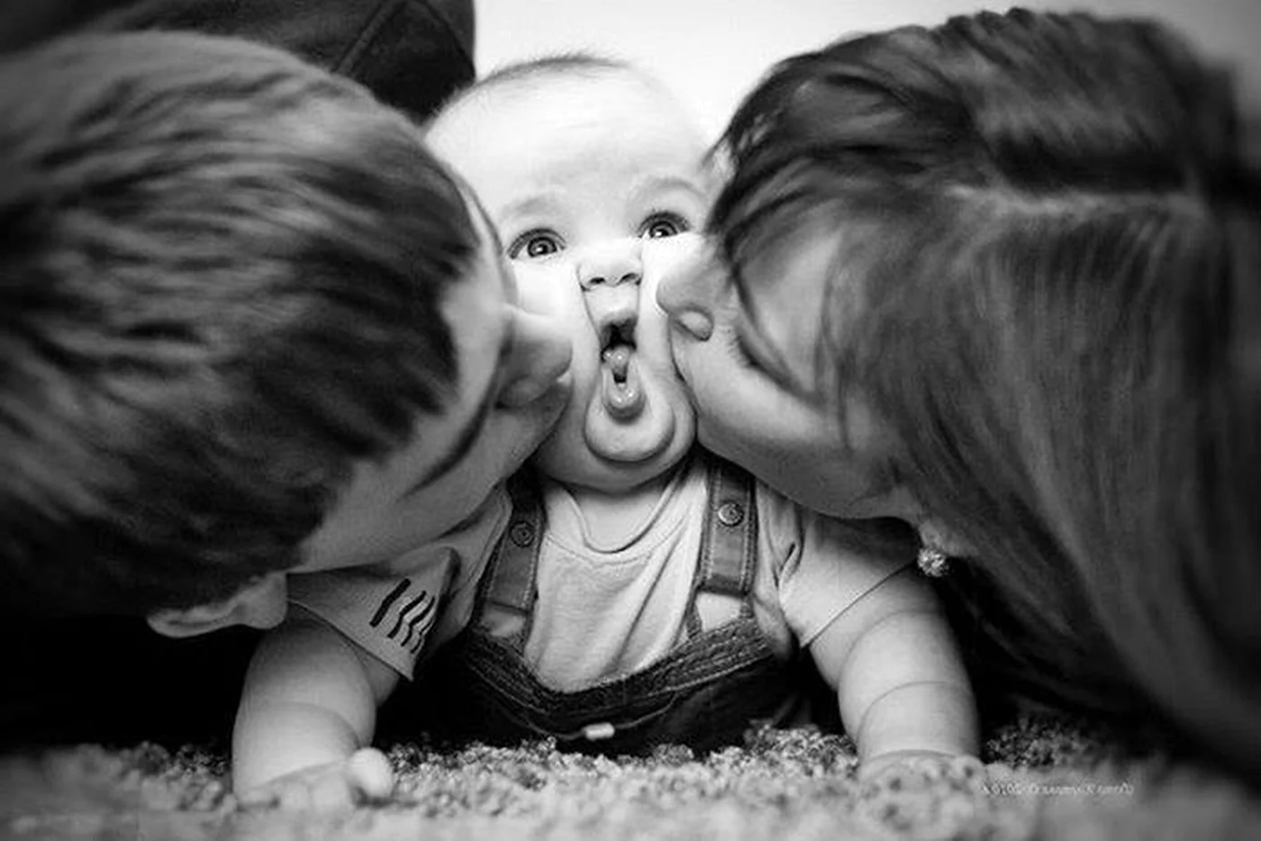 Родители целуют малыша