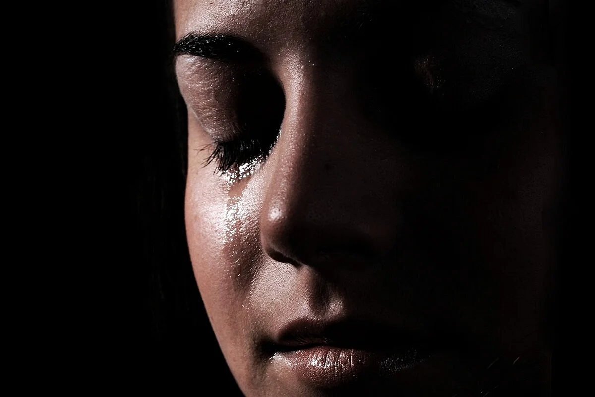 Девушка плачет в темноте